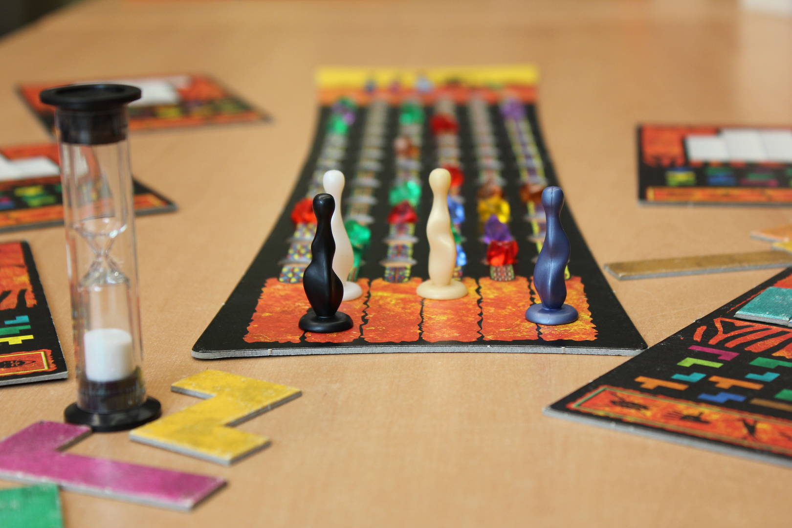 Set including game board, game pieces, and a sand timer (Ubongo)