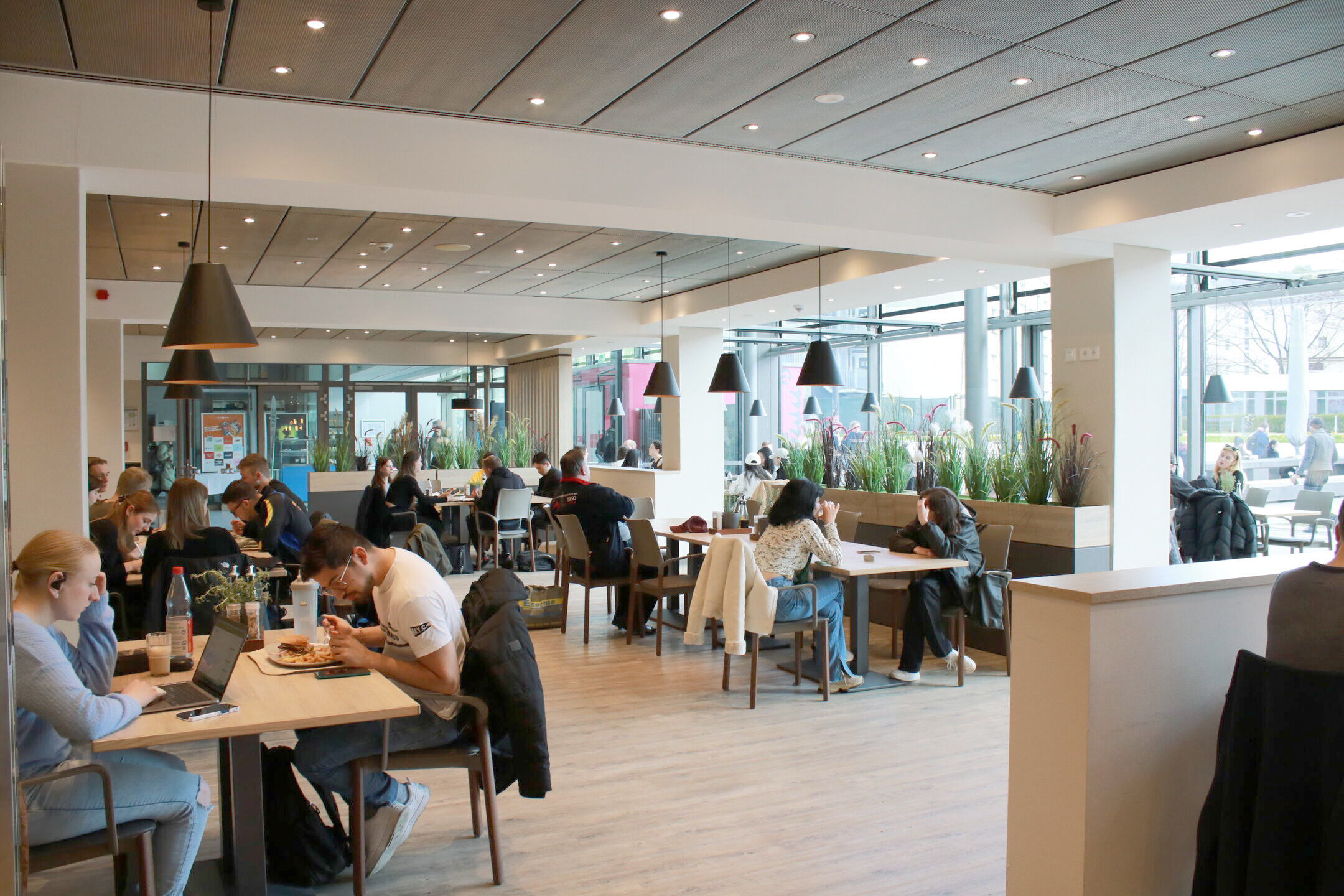 A modern dining room with guests eating or working