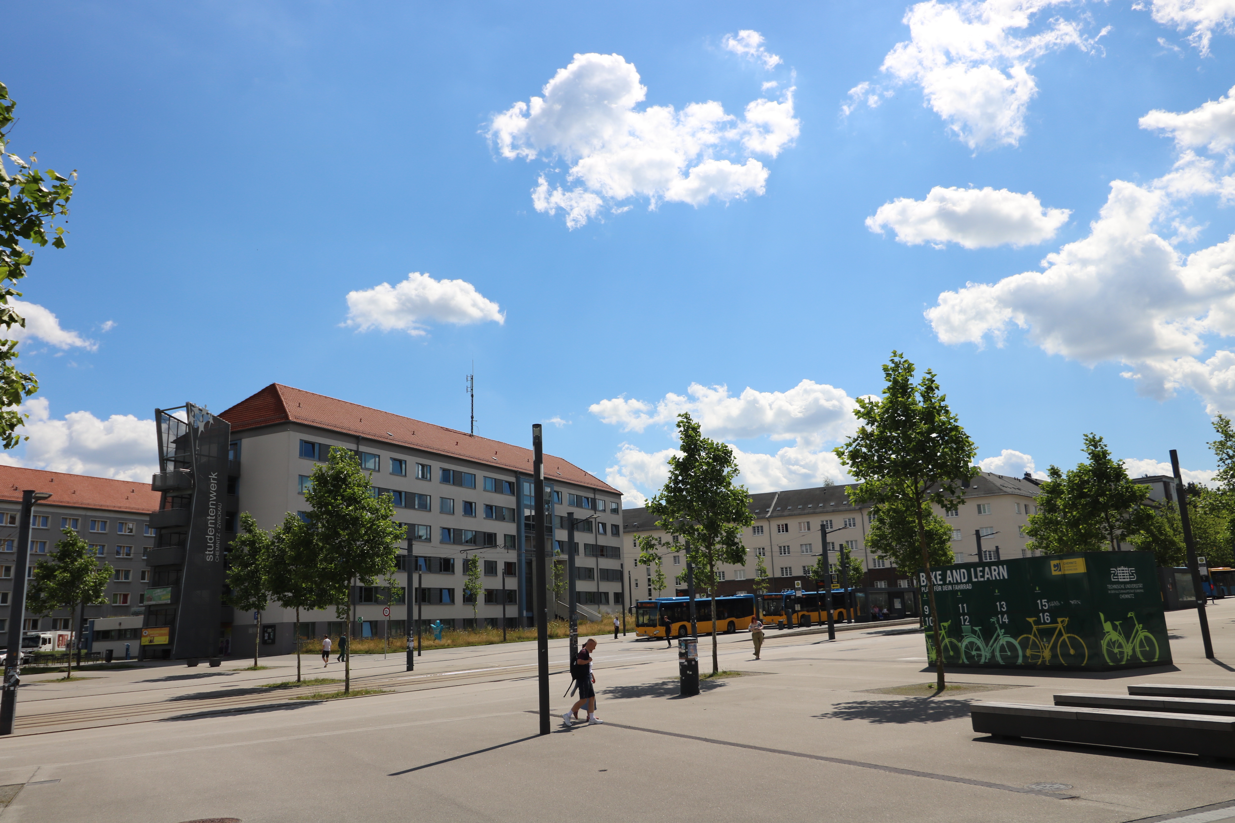 Gebäude auf Campus mit Haltstelle direkt davor