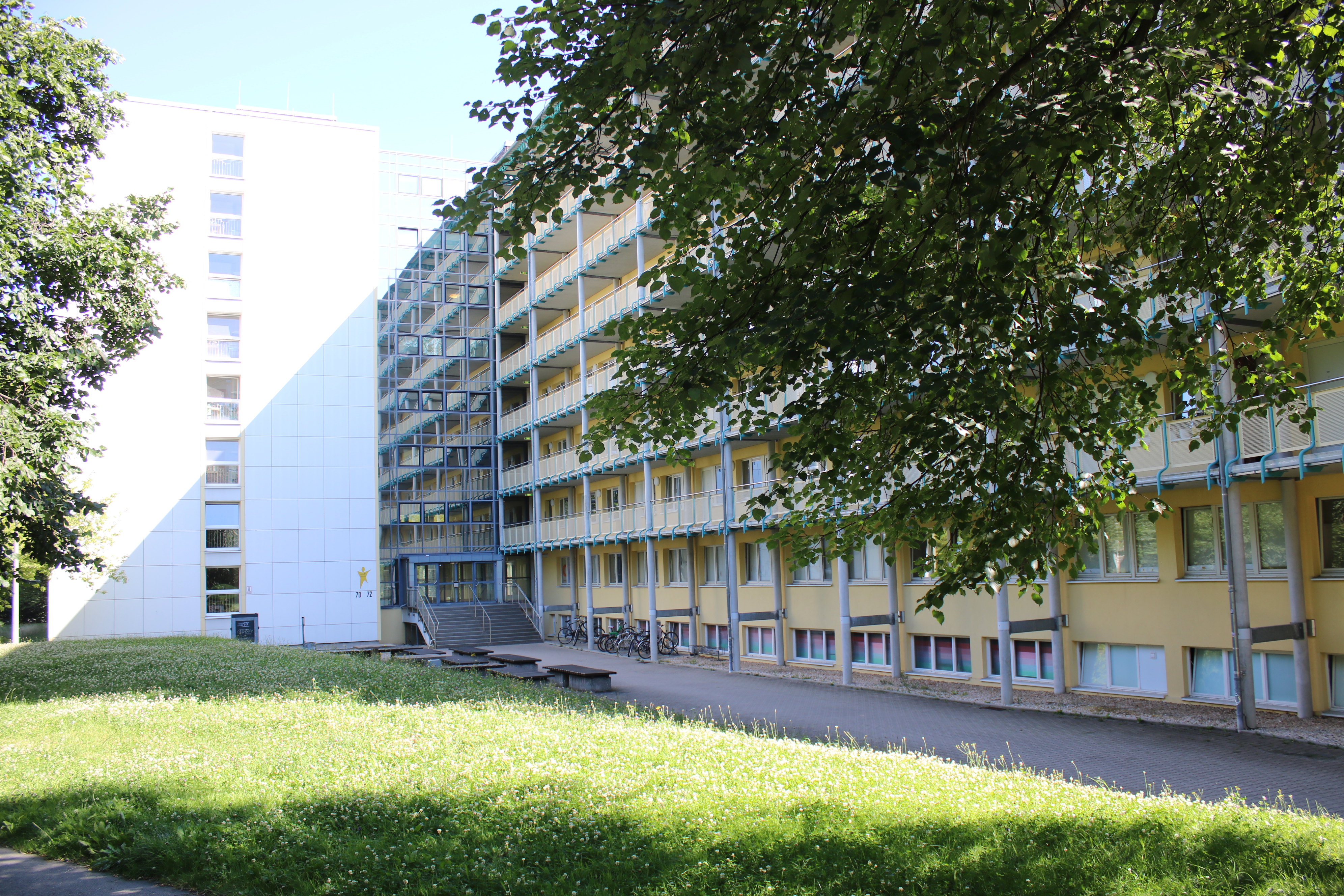 ein Wohnheim mit Bogengang im Grünen